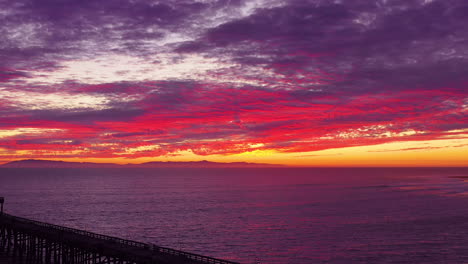 An-astonishing-sunset-vista-aérea-shot-over-a-long-pier-and-the-Pacific-Ocean-and-Channel-Islands-in-Ventura-Southern-California-1