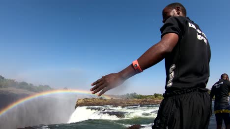 A-man-dives-into-Devil's-Pool-the-edge-of-Victoria-Falls-Zambia-close-to-the-edge-of-the-waterfalls-1