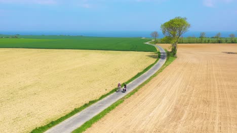 Beautiful-aerial-of-a-French-couple-riding-bicycles-through-the-green-countrside-of-Normandy-France