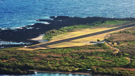 High-angle-establishing-shot-of-Kalaupapa-airport-and-small-plane-landing-on-the-island-of-Molokai-Hawaii