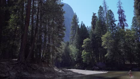 Un-Niño-Juega-En-Las-Tranquilas-Aguas-Del-Río-Merced-En-Un-Soleado-Día-De-Otoño-En-El-Valle-De-Yosemite-Yosemite-NP-CA