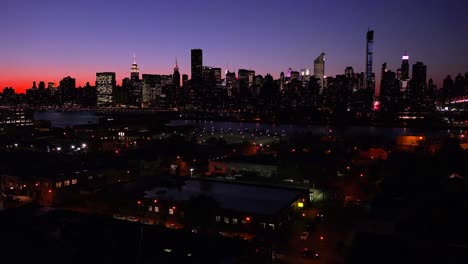 Ein-Weitwinkel-Blick-über-Queens-New-York-City-In-Der-Abenddämmerung-Mit-Dem-Manhattan-Skyline-Hintergrund-1