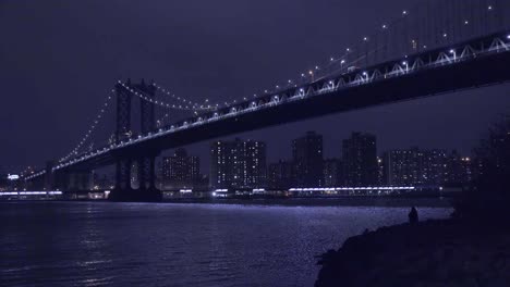 U-Bahnen-überqueren-Die-Brooklyn-Bridge-Mit-Der-Skyline-Von-New-York-City-Im-Hintergrund-Bei-Nacht-1