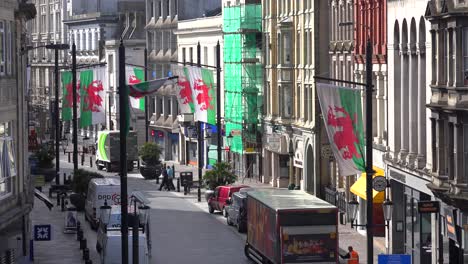 Establishing-shot-of-a-narrow-street-lined-with-Welsh-flags-in-downtown-Cardiff-Wales