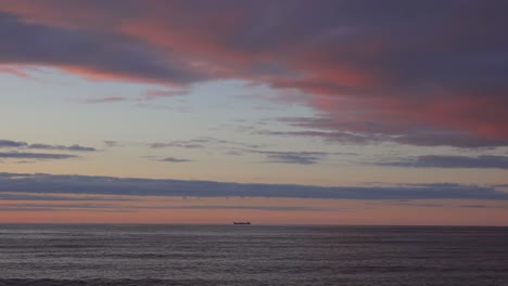 Ein-Sehr-Weit-Entferntes-Frachtschiff-Am-Horizont-Bei-Sonnenuntergang