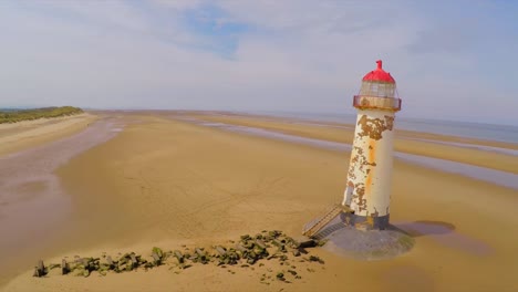 A-magnificent-aerial-shot-of-the--Point-of-Ayr-lighthouse-in-Wales-with-weathered-fence-in-foreground-1