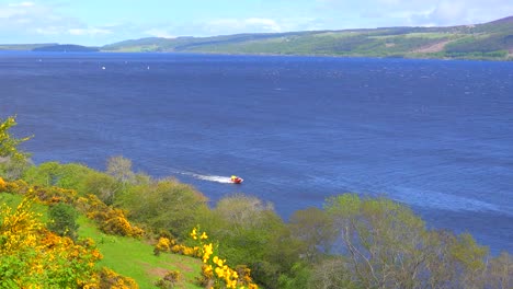 Eine-Einleitende-Aufnahme-Von-Loch-Ness-Schottland-Mit-Vorbeifahrendem-Schnellboot
