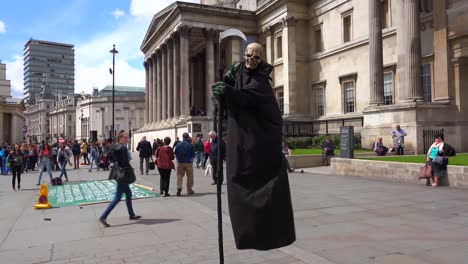 Ein-Straßenkünstler-Spielt-Den-Sensenmann-Am-Trafalgar-Square-In-London;