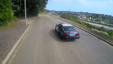 Eine-Luftaufnahme-über-Einem-Polizeiauto,-Das-Auf-Einer-Straße-Fährt