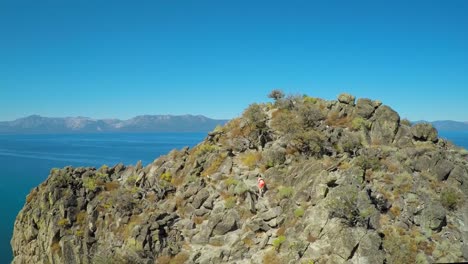 An-aerial-shot-over-a-hiker-on-a-mountaintop-in-Lake-Tahoe-Nevada