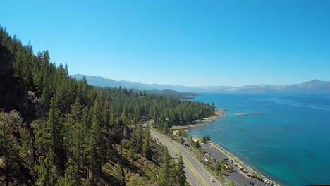 An-aerial-shot-over-a-highway-running-along-the-shoreline-of-Lake-Tahoe