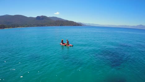 Eine-Luftaufnahme-Einer-Frau-Und-Eines-Mannes,-Die-Auf-Einem-Paddle-Board-Am-Lake-Tahoe-Sitzen