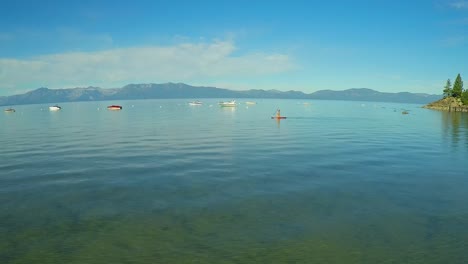 An-aerial-shot-of-a-woman-and-her-dog-paddle-boarding-on-Lake-Tahoe-2
