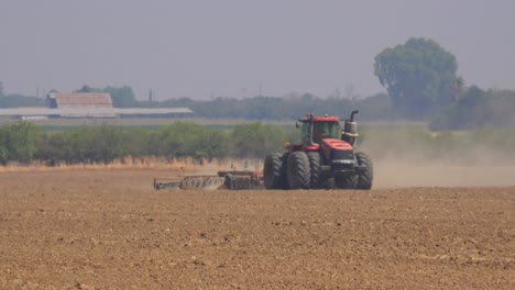 A-farmer-drives-a-tractor-across-barren-fields