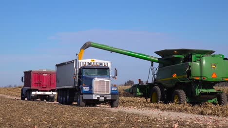 A-harvester-loads-grain-into-a-truck-on-a-rural-farm-in-America