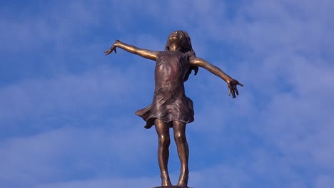 Eine-Statue-Eines-Jungen-Mädchens-Mit-Weit-Geöffneten-Armen,-Die-Die-Welt-Umarmt,-Sitzt-In-Einem-Park-In-Wisconsinin