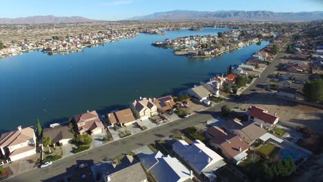 Aerial-over-a-suburban-neighborhood-in-the-desert-with-an-artificial-lake-distant-2