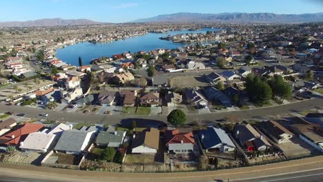 Aerial-over-a-suburban-neighborhood-in-the-desert-with-an-artificial-lake-distant-3
