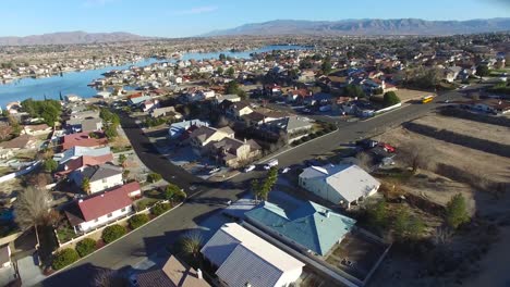 Aerial-over-a-suburban-neighborhood-in-the-desert-with-an-artificial-lake-distant-4