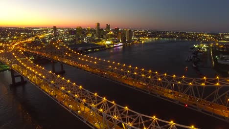Beautiful-night-stationary-aerial-shot-of-the-Crescent-City-Bridge-over-the-Mississippi-River-revealing-the-New-Orleans-Louisiana-skyline