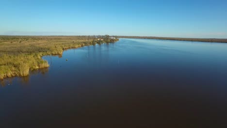 An-aerial-over-the-Louisiana-bayou-reveals-a-house-on-stilts