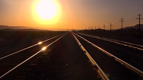 Eine-Aufnahme-Von-Eisenbahnschienen,-Die-Sich-Bei-Sonnenuntergang-Bis-Zum-Horizont-Erstrecken