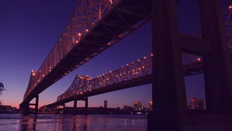 El-Puente-De-La-Ciudad-Creciente-En-La-Noche-Con-Nueva-Orleans,-Louisiana-En-El-Fondo