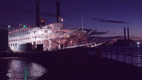 Beautiful-shot-of-a-large-Mississippi-paddlewheel-riverboat-docked-at-night-near-New-Orleans