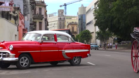 Classic-old-cars-and-horse-carts-are-driven-through-the-colorful-streets-of-Havana-Cuba