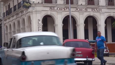 Pedestrians-walk-around-the-outside-of-Sloppy-Joe's-Bar-and-restaurant-in-the-old-city-of-Havana-Cuba