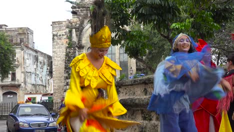 Mujeres-Con-Trajes-Coloridos-Bailan-Sobre-Pilotes-En-Las-Calles-De-La-Habana,-Cuba
