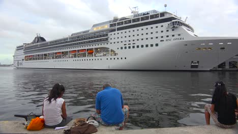 Massive-Kreuzfahrtschiffe-Legen-Im-Hafen-Von-Havanna-An,-Während-Sich-Kubanische-Schaulustige-Versammeln,-Um-Sie-Zu-Bestaunen