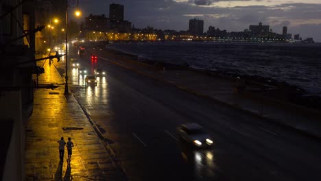 Schöne-Nachtaufnahme-Des-Malecon-In-Havanna-Kuba-Mit-Vorbeifahrenden-Autos