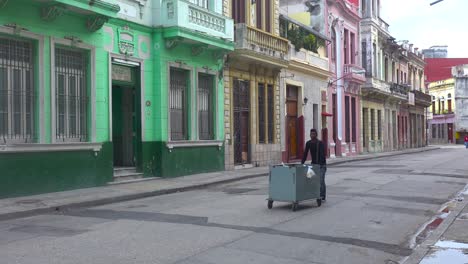 Un-Vendedor-Ambulante-Camina-Por-Un-Bulevar-En-La-Habana,-Cuba,-Vendiendo-Sus-Productos.