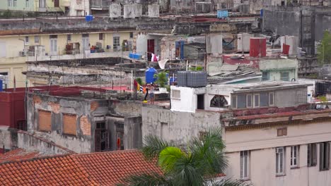 Zoom-out-from-woman-doing-laundry-reveals-the-skyline-of-Havana-Cuba