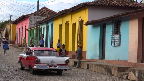 A-beautiful-shot-of-the-buildings-and-cobblestone-streets-of-Trinidad-Cuba-with-old-classic-car-passing