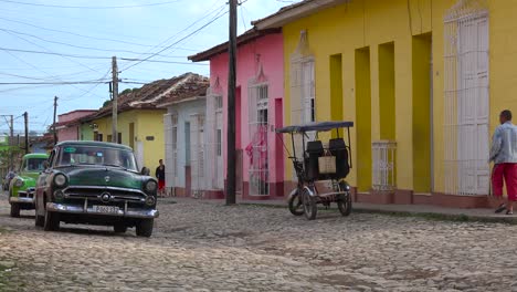 A-beautiful-shot-of-the-buildings-and-cobblestone-streets-of-Trinidad-Cuba-with-old-classic-car-passing-2
