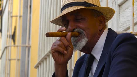 A-cuban-man-smokes-a-cigar-on-the-colorful-streets-of-Trinidad-Cuba