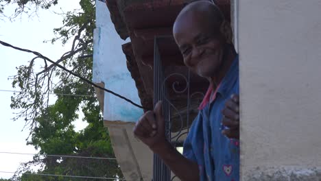 A-friendly-old-man-waves-gives-the-thumbs-up-and-smiles-in-Trinidad-Cuba