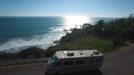 Aerial-over-a-motorhome-traveling-along-a-California-road-near-the-ocean