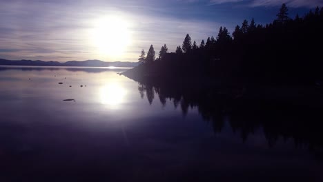 A-beautiful-vista-aérea-shot-over-Lake-Tahoe-with-the-shoreline-in-silhouette