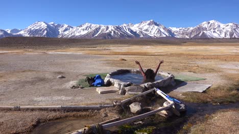 A-woman-sits-in-a-natural-hot-pool-in-the-Sierra-Nevada-mountains-near-Mammoth-California--1