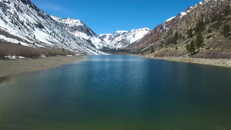 A-beautiful-vista-aérea-over-a-montaña-lake-reveals-the-Sierra-Nevada-montañas-in-winter-with-plentiful-water-1