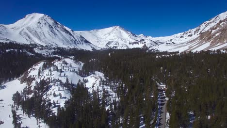 An-aerial-over-a-remote-road-through-the-snowy-Sierra-Nevada-mountains-in-winter