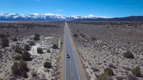 Antenne-über-Einem-4wd,-Der-Auf-Einer-Asphaltierten-Straße-In-Der-Mojave-Wüste-Mit-Den-Bergen-Der-Sierra-Nevada-In-Der-Ferne-Fährt-1