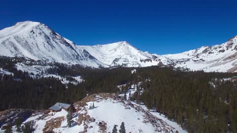 Eine-Antenne-über-Einer-Abgelegenen-Verlassenen-Hütte-Auf-Einem-Berggipfel-In-Den-Hohen-Sierra-Nevada-Bergen-Im-Winter-4