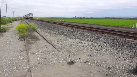 Ein-Amtrak-Zug-Fährt-Mit-Hoher-Geschwindigkeit-Durch-Kalifornische-Farmfelder