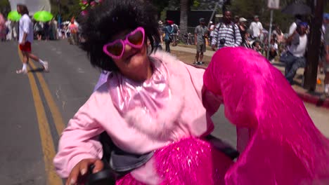 A-woman-dressed-in-pink-rocks-out-in-a-wheelchair-during-the-summer-solstice-parade-in-Santa-Barbara-California