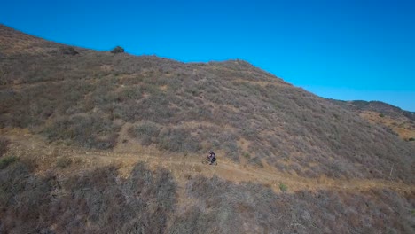 Good-aerial-following-a-mountain-biker-ascending-a-California-mountain