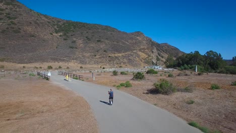 Aerial-footage-following-a-man-riding-an-electric-unicycle-down-a-road-in-California-2